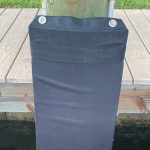 A black bag on a wooden post.