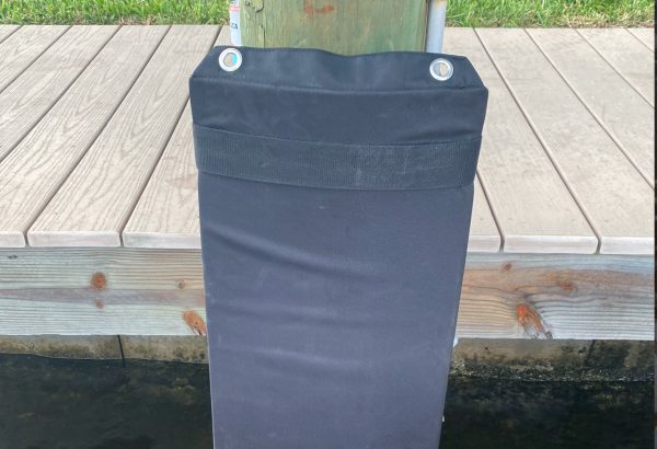 A black bag on a wooden post.